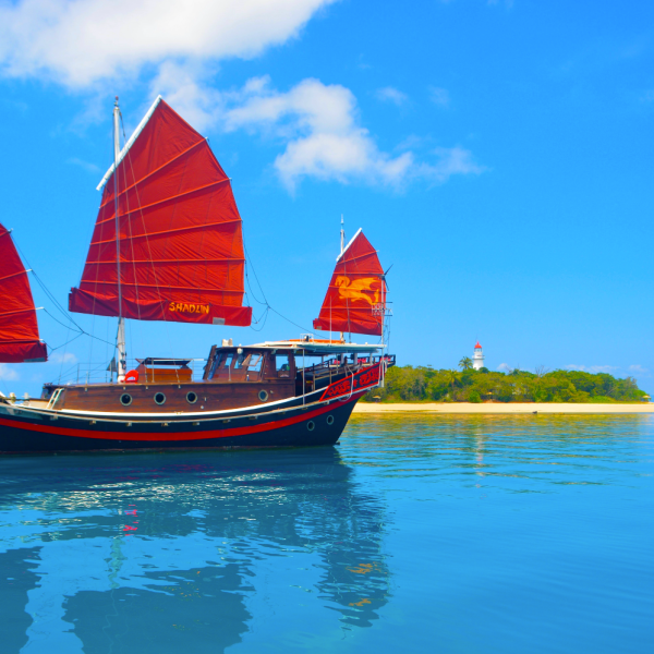 a blue and white boat sitting next to a body of water