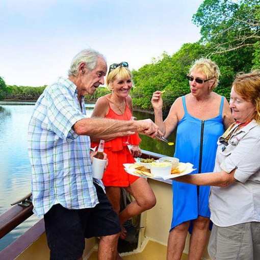 a group of people are drinking from a lake