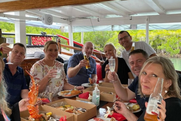 a group of people sitting at a table with food