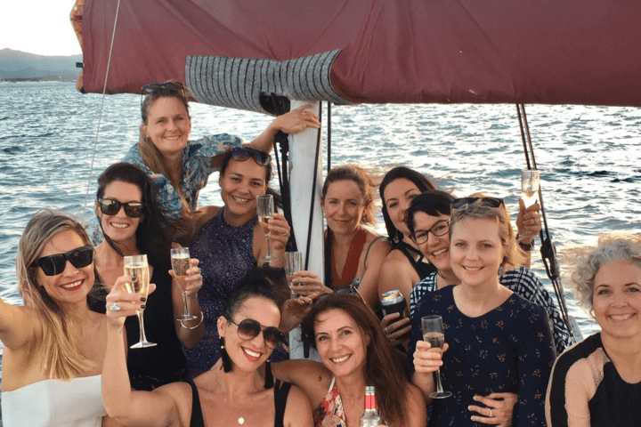 a group of people posing in front of a body of water