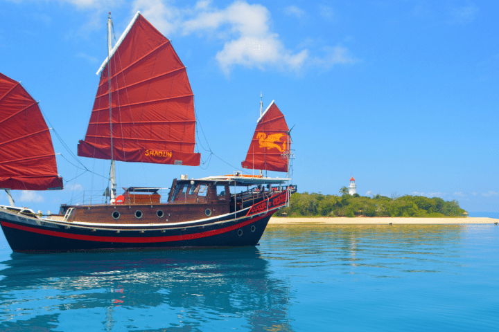 a small boat in a body of water with Ha Long Bay in the background